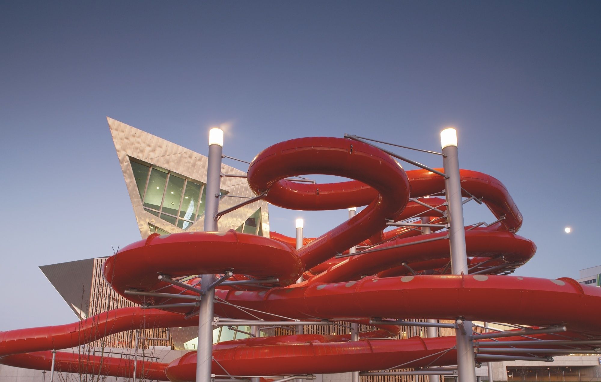 Water park Bernaqua with red slides and evening sky.