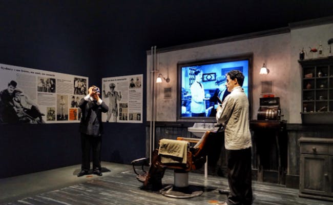 Chaplinův svět v Montreux ukazuje scénu barber shopu s postavami a historickými obrázky.