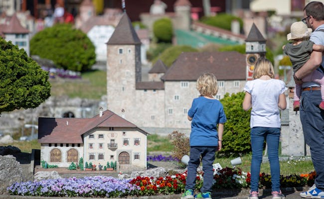 Swissminiatur med barn som tittar på modeller, blommor