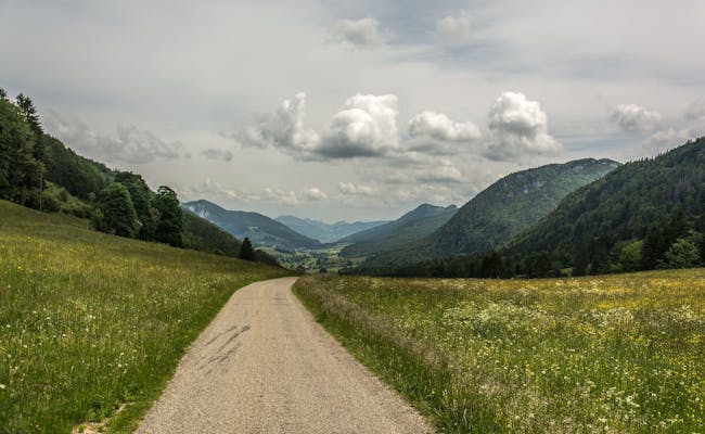 Krajina: Rozlehlá louka v přírodním parku Thal s horami a krásným nebem.
