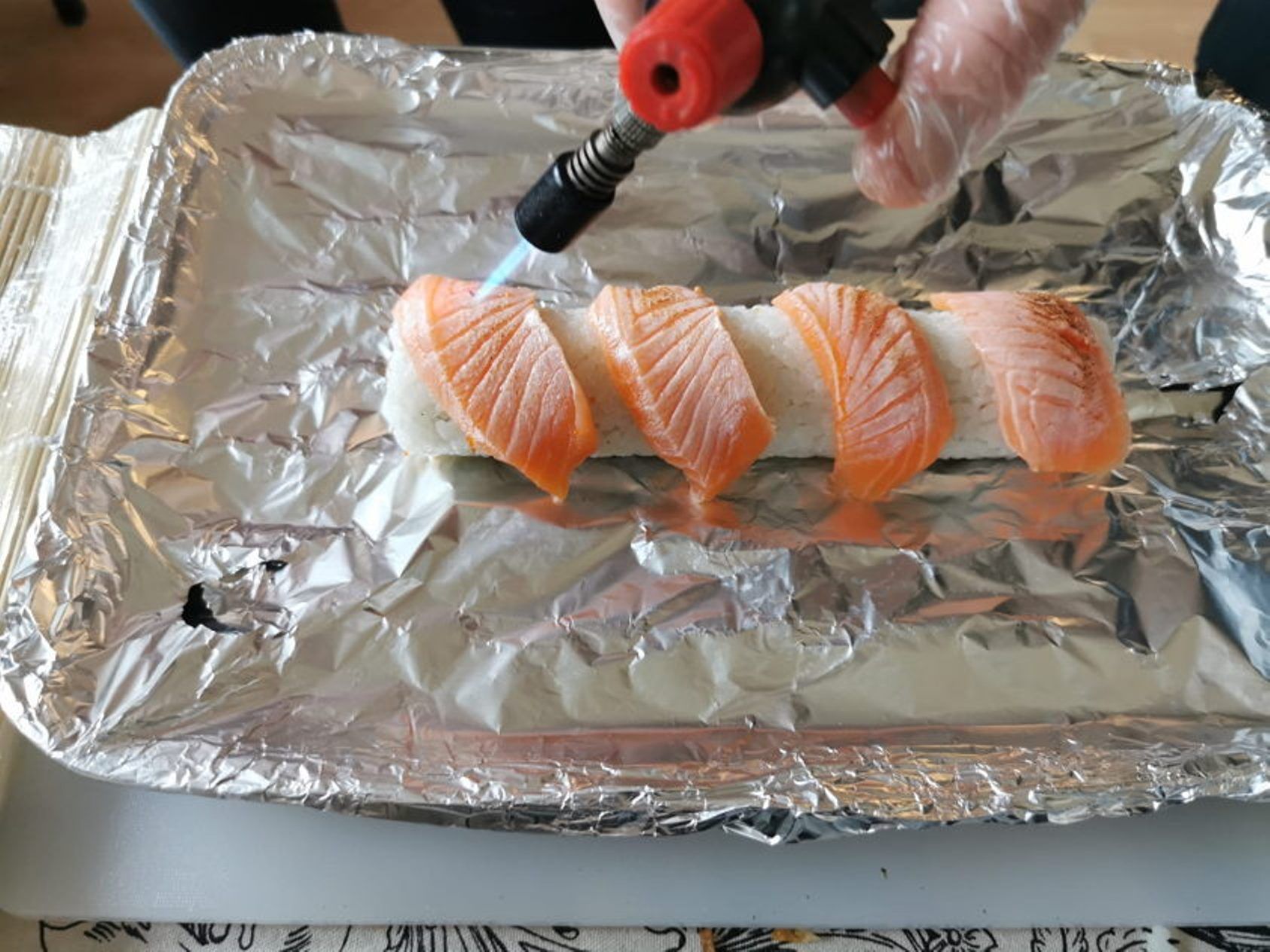 Курс по суши Люцерн: фламбирование суши с лососем на тарелке