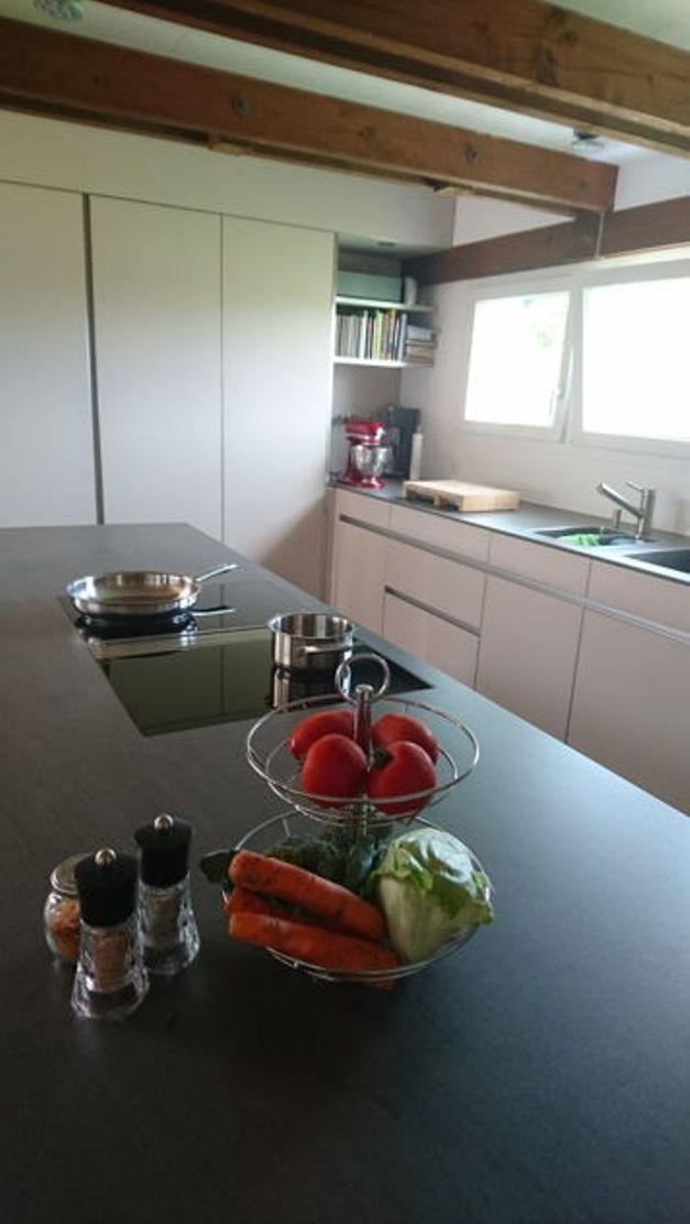 Cozinha moderna com fogão, panelas, janelas.