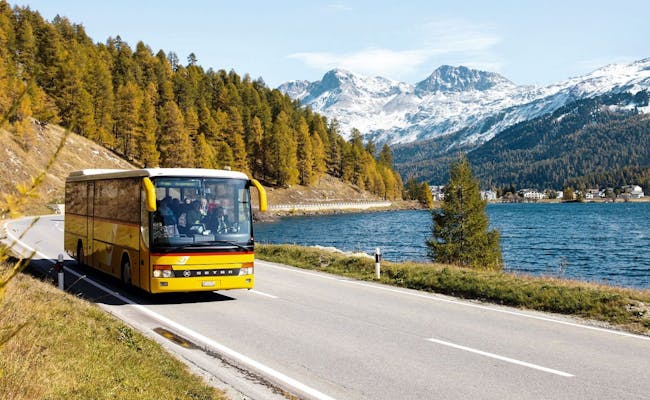 Offentlig transport gennem Schweiz: Rejse med Postbus og udsigt over bjergene og søen.