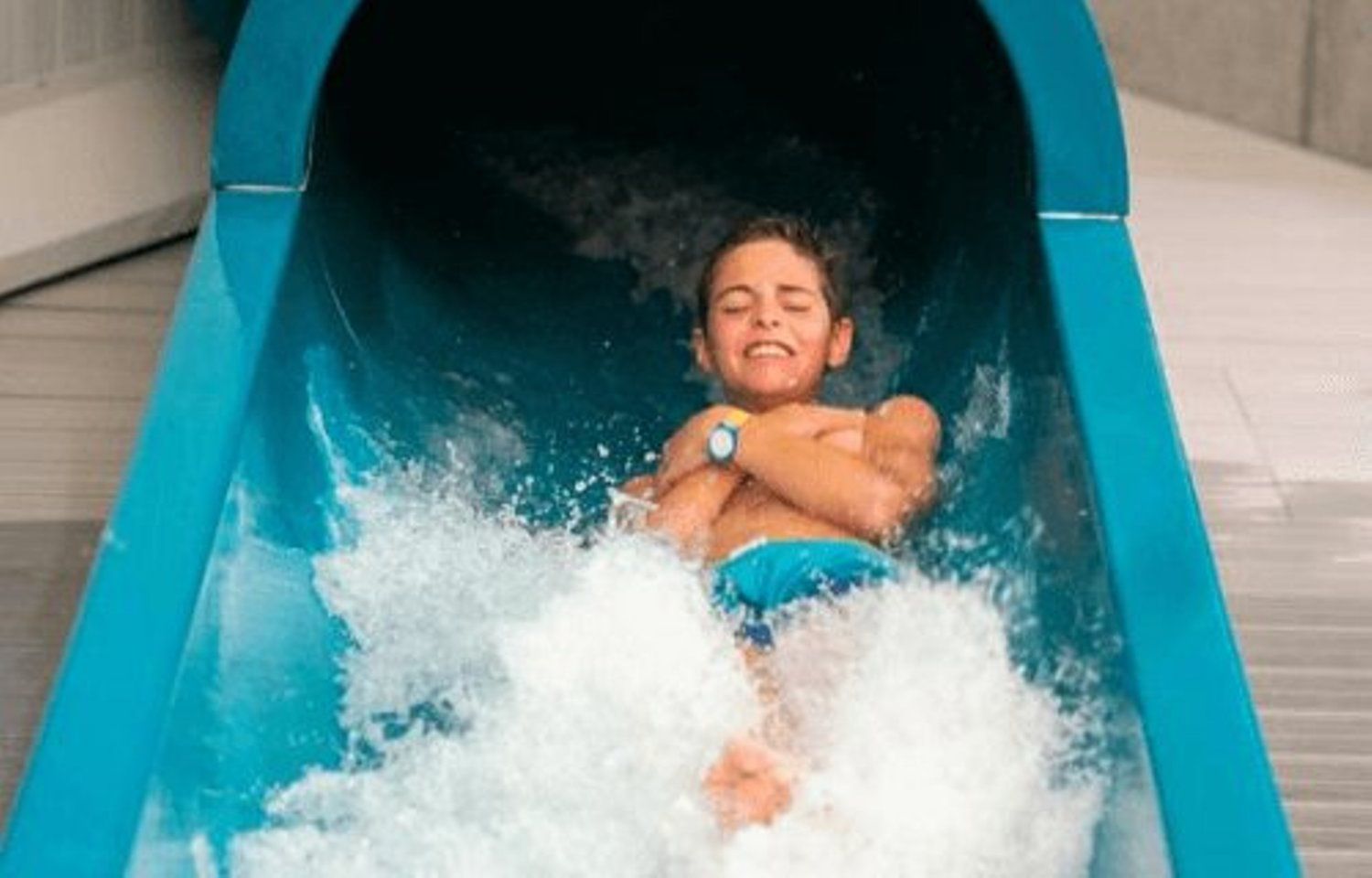 Child smiling as they slide down the water slide at the Splash & SPA water park.