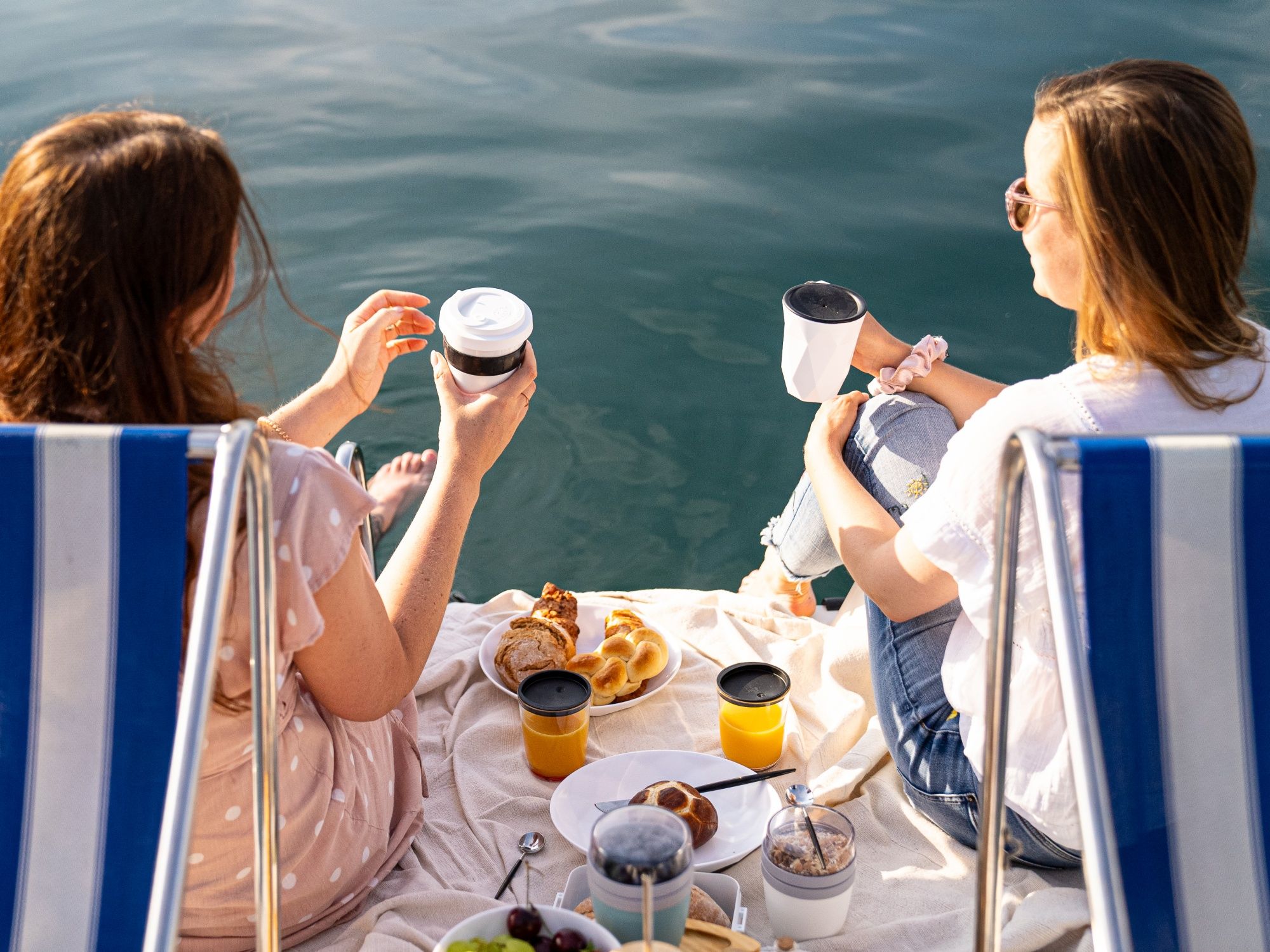 Půjčení člunu na jarní snídani s přáteli u vody za slunečného dne s osvěžujícími nápoji.