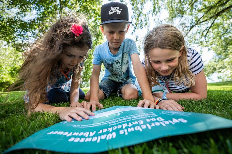 Kinderen spelen aan het Walensee op een grasveld en ontdekken het avontuur parcours.