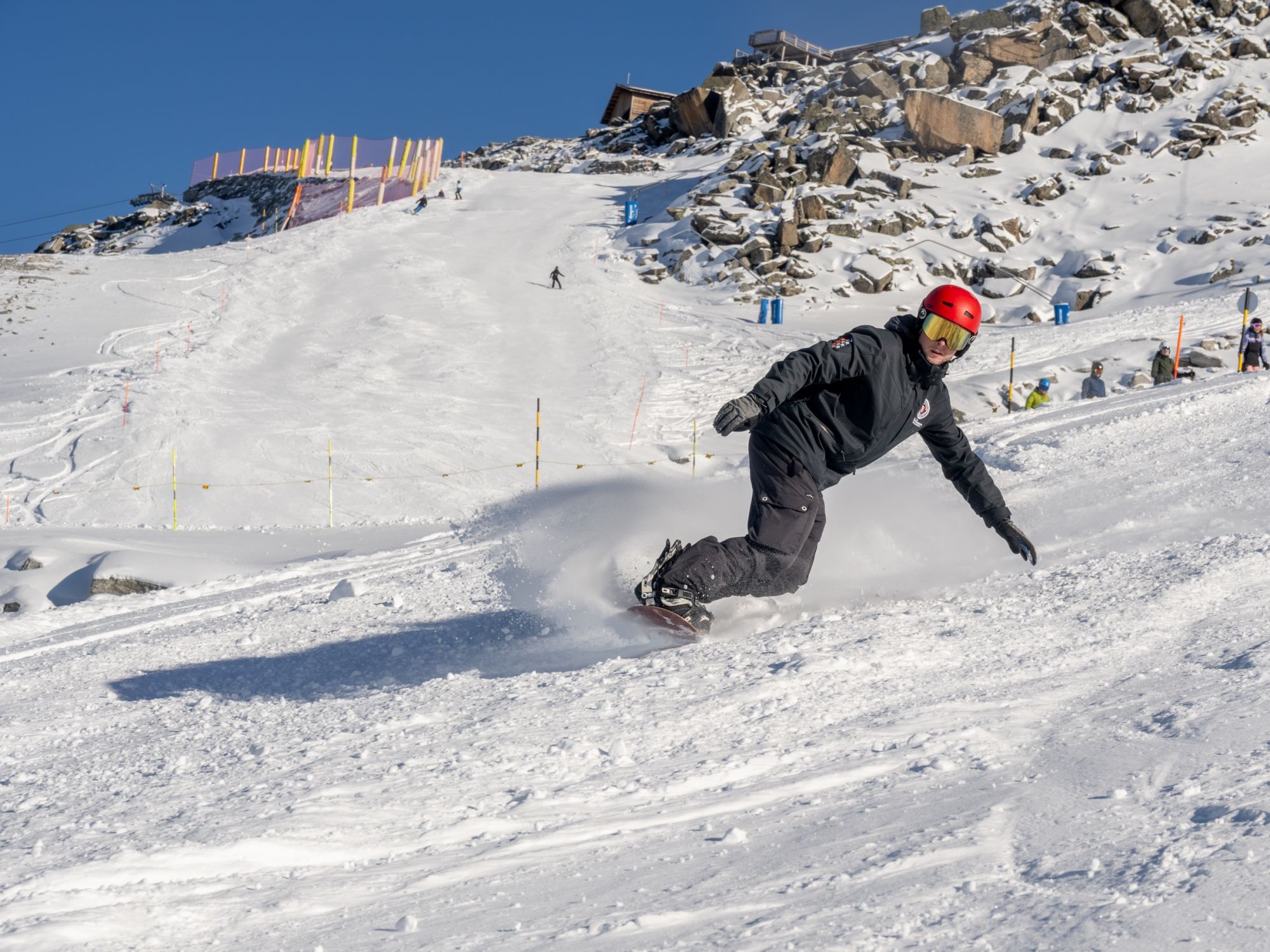 Snowboardles: Groepsles voor beginners op besneeuwde pistes bij prachtig winterweer.