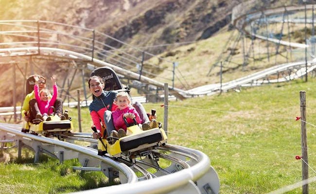 Sommer Rodelbahn Monte Tamaro mit Familienaktivität im Grünen.
