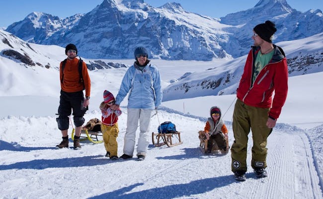 Rodzina na sanki w regionie Jungfrau, zimowa aktywność, ośnieżone góry