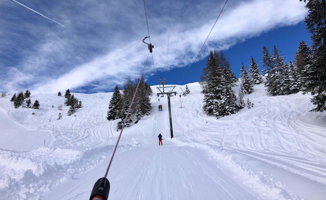 Estación de esquí Tschiertschen: Esquiadores en el telesilla en invierno, montañas cubiertas de nieve.