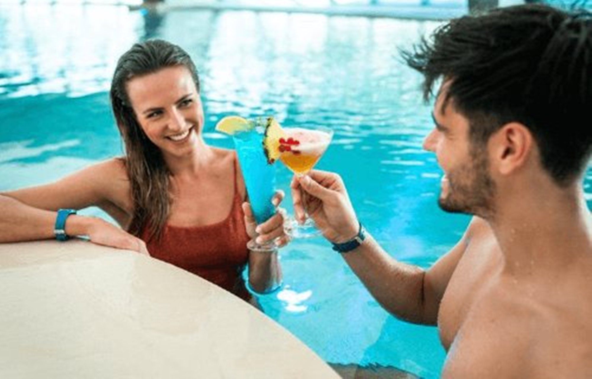 Water park Splash & SPA. Couple enjoys cocktails by the pool. Relaxed atmosphere.