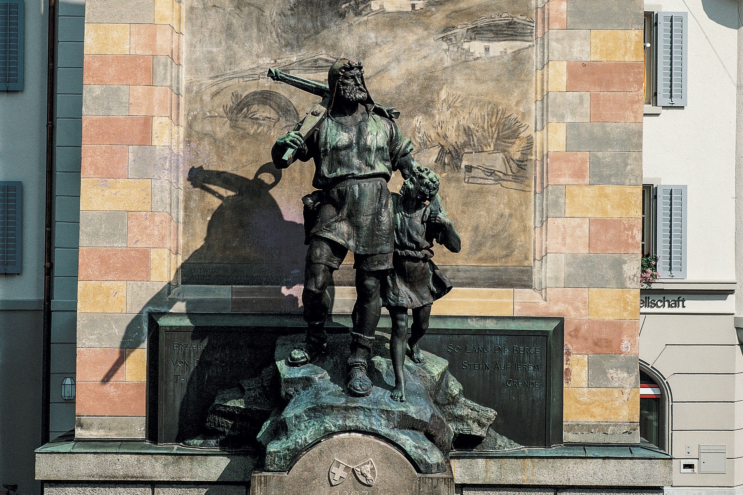 Socha Tella v Altdorfu, Heinrich Tell s dítětem, bronzová socha, historické prostředí.