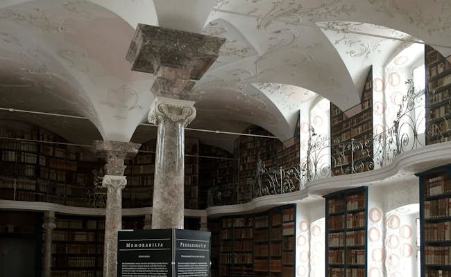 Sala da biblioteca no Mosteiro de Einsiedeln com encadernações históricas e uma arquitetura impressionante.