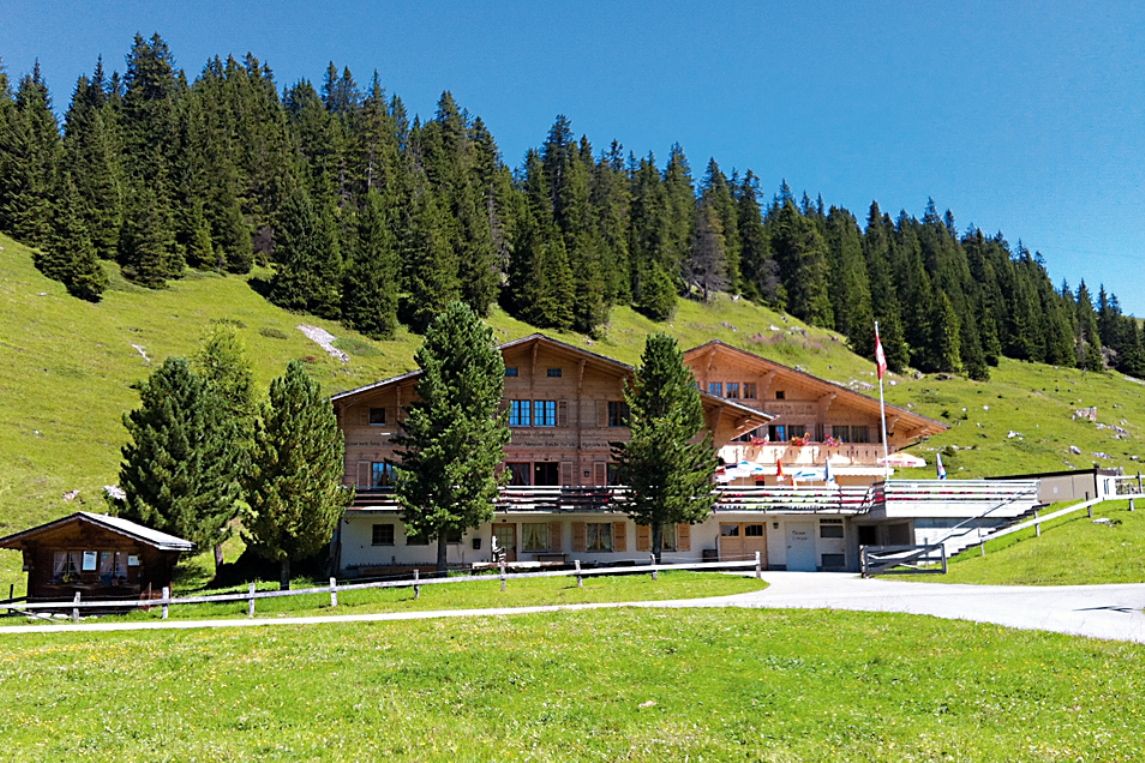 Estação SUP no Brandsee Elsigen-Metsch com paisagem montanhosa ao fundo.
