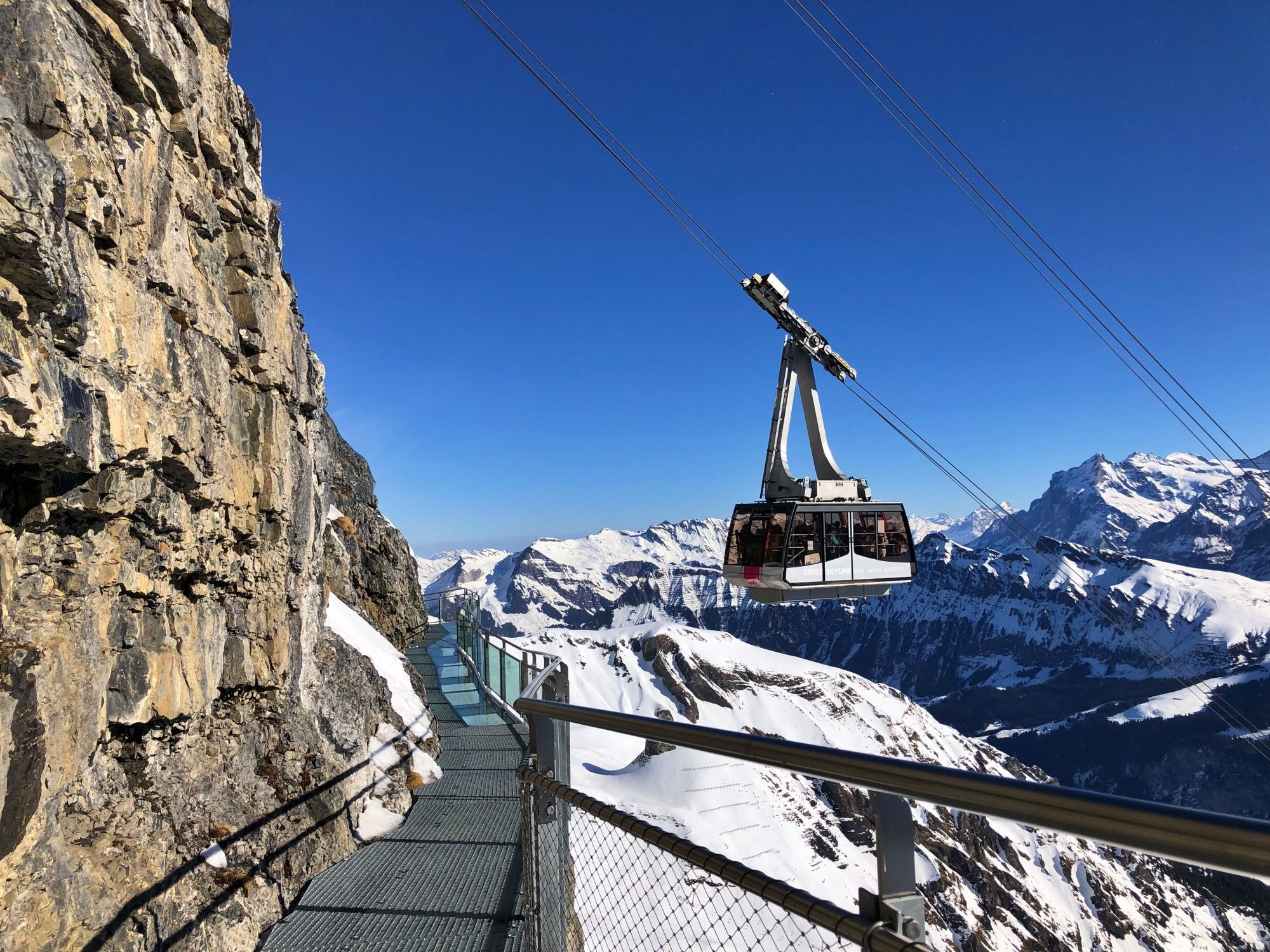 Schilthorn Thrill Walk : vue imprenable sur des montagnes enneigées et le téléphérique vers la plateforme.
