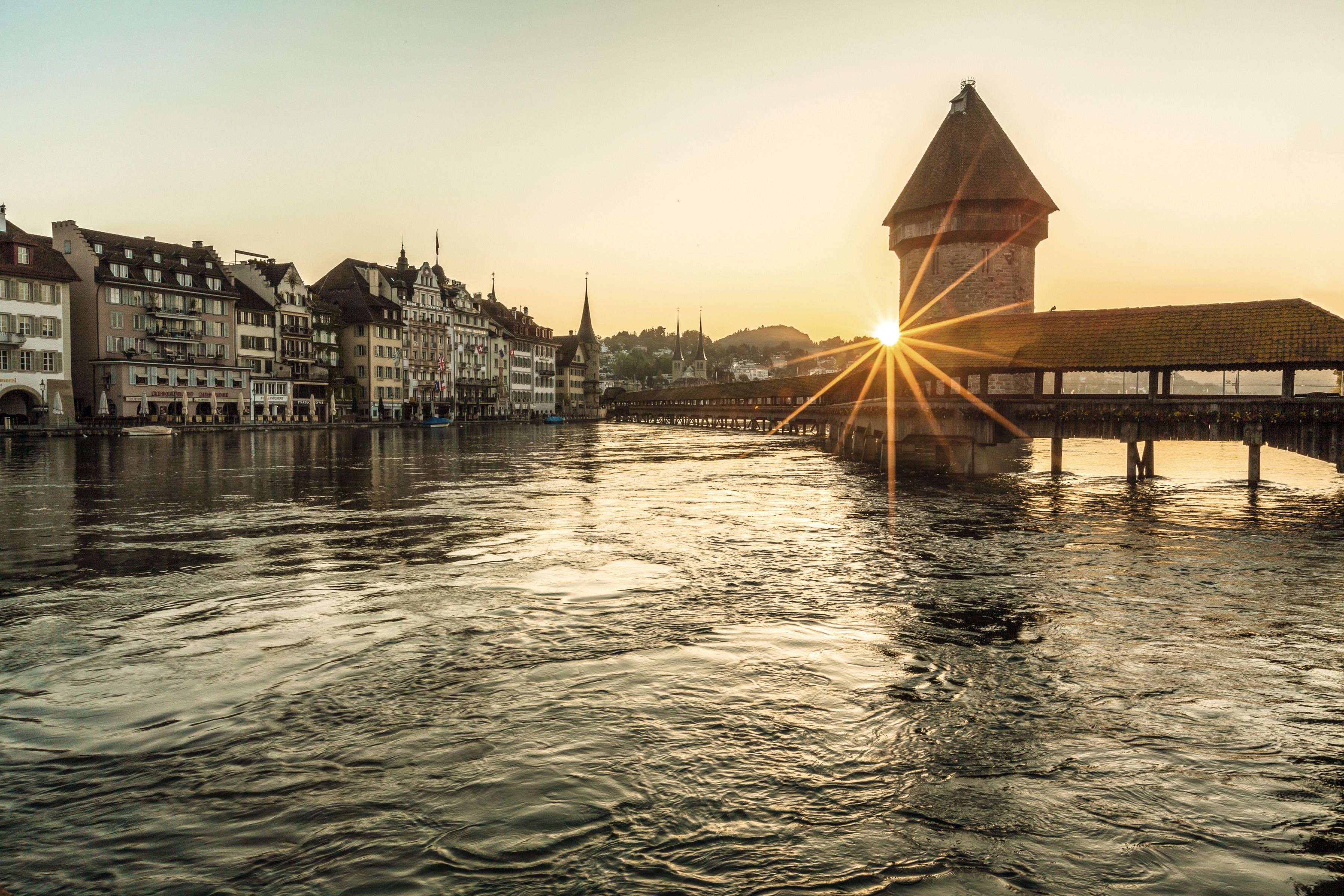Chapel Bridge in Lucerne: impressive city view with water and architecture, experience the summer mood.