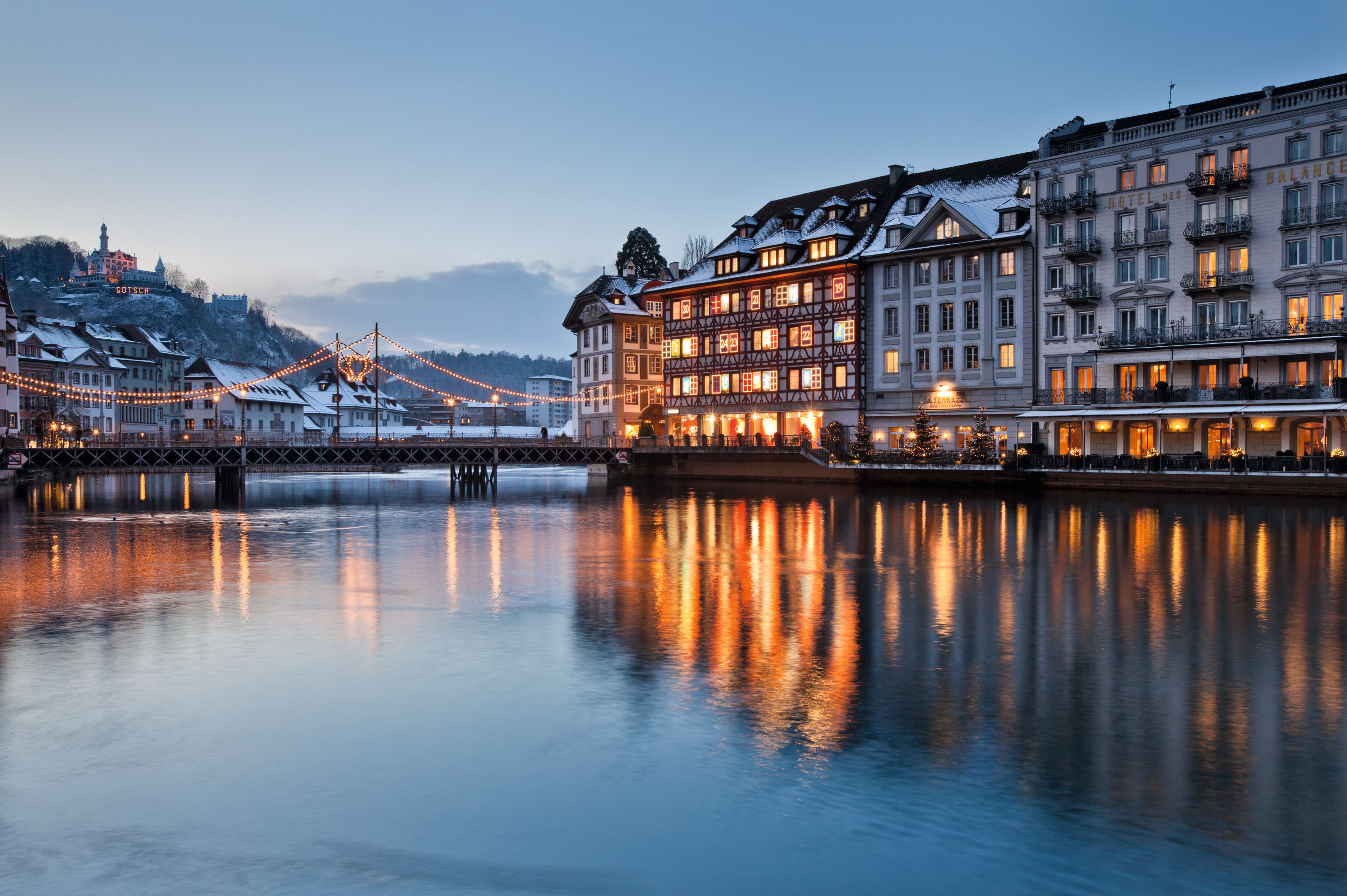 Lucerne: winter city view by the lake with pretty buildings and reflecting lights.