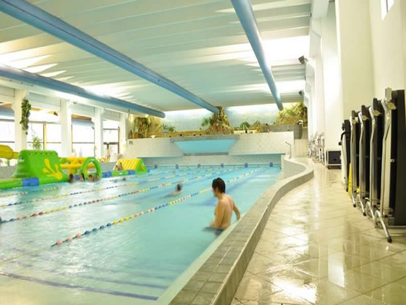 California Aquapark with swimming pool and slides, bathers and equipment in the background