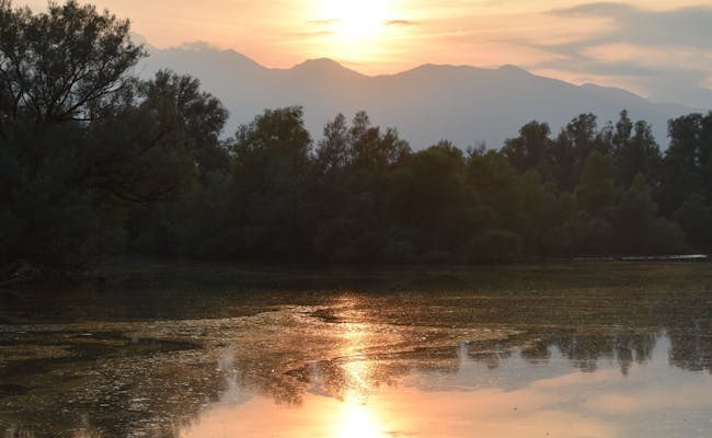 Lago Maggiore: pemandangan yang menakjubkan ke atas air, gunung dan matahari terbenam di Gambarogno.