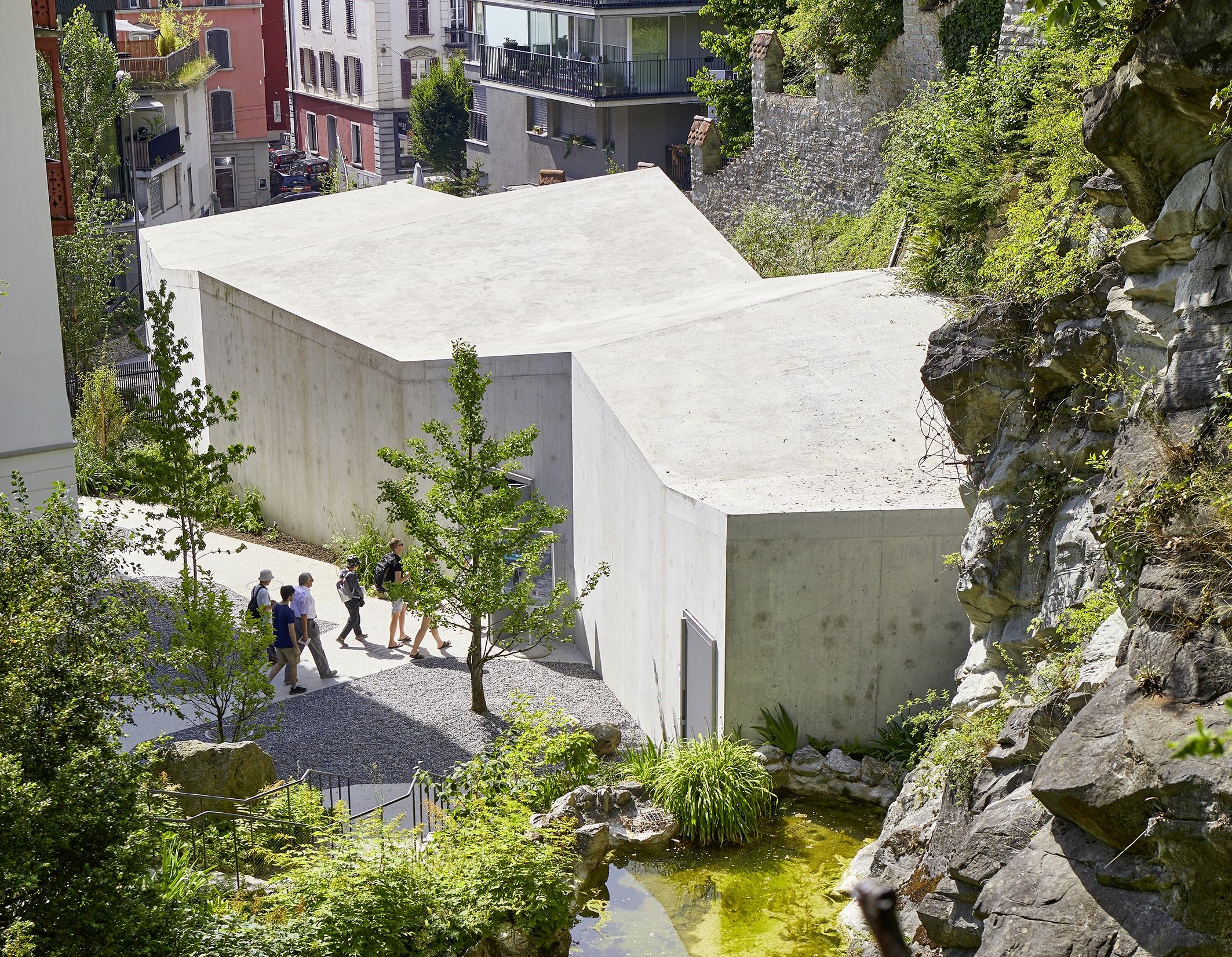 Sandstenspavillon i Gletscherhagen i Luzern, moderne arkitektur omgivet af natur og grønne områder.