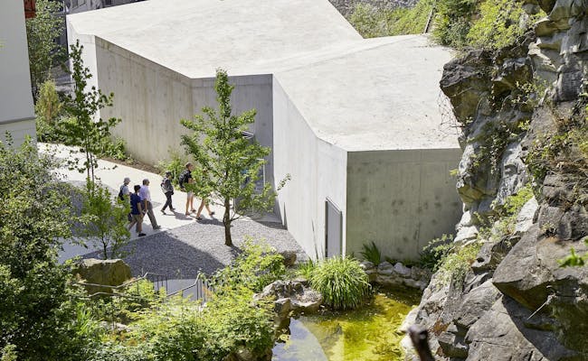 Sandstone pavilion in the Glacier Garden Lucerne, modern architecture surrounded by nature and green spaces.