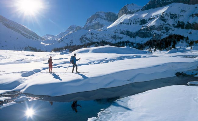 Lompat ski di Kandersteg, lapisan salju segar, pemandangan pegunungan, dan matahari