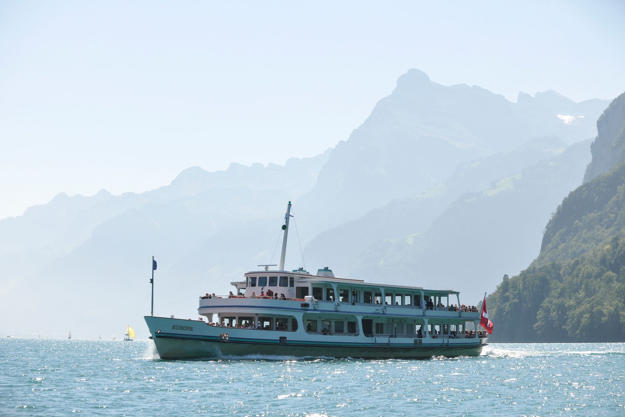 Fartyg på vattnet nära bergen, perfekt för utflykter och naturopplevelser.