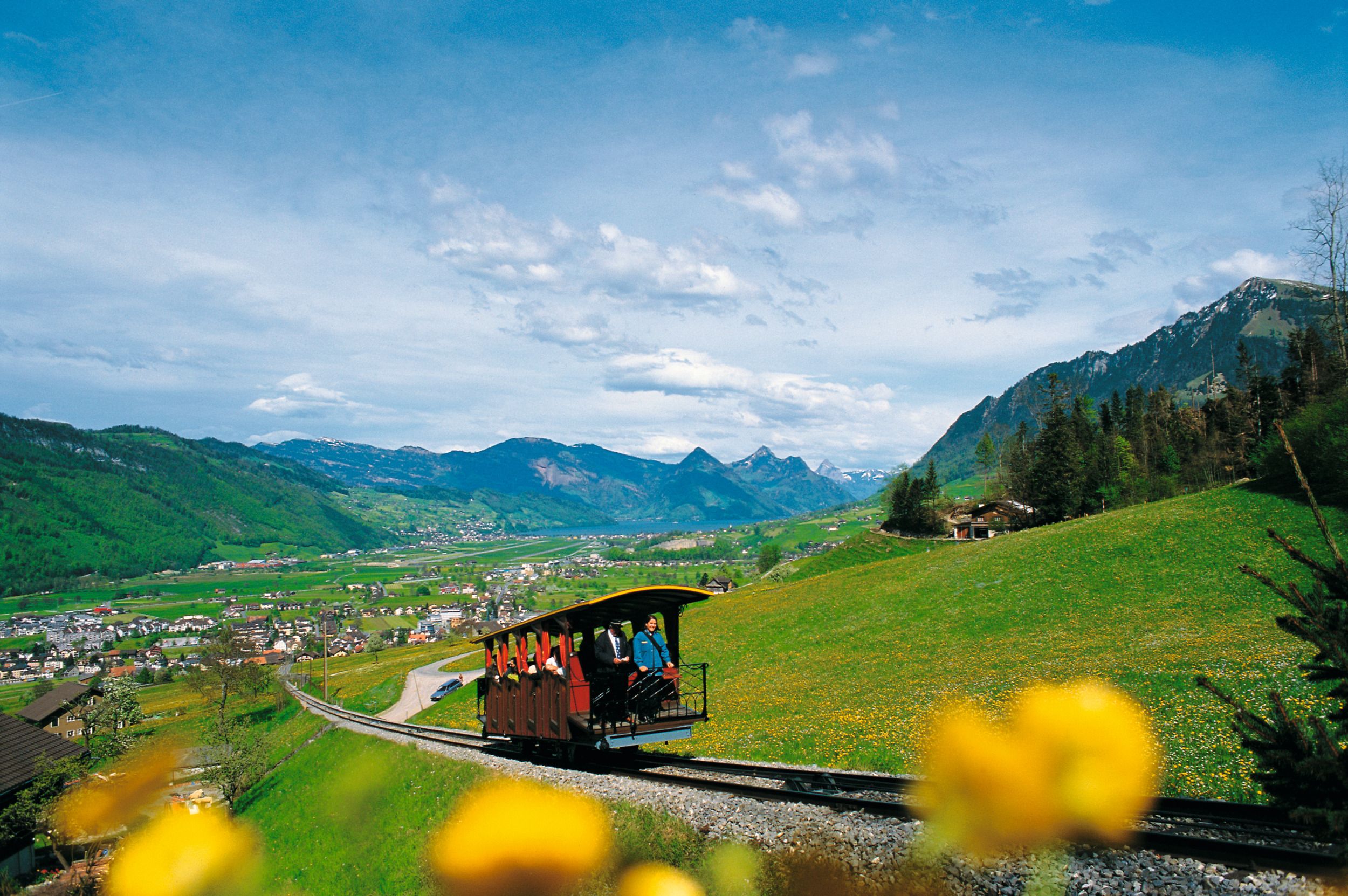 Stanserhorn : Découvre le trajet pittoresque en train à travers la nature au cœur de la Suisse avec des prairies fleuries.