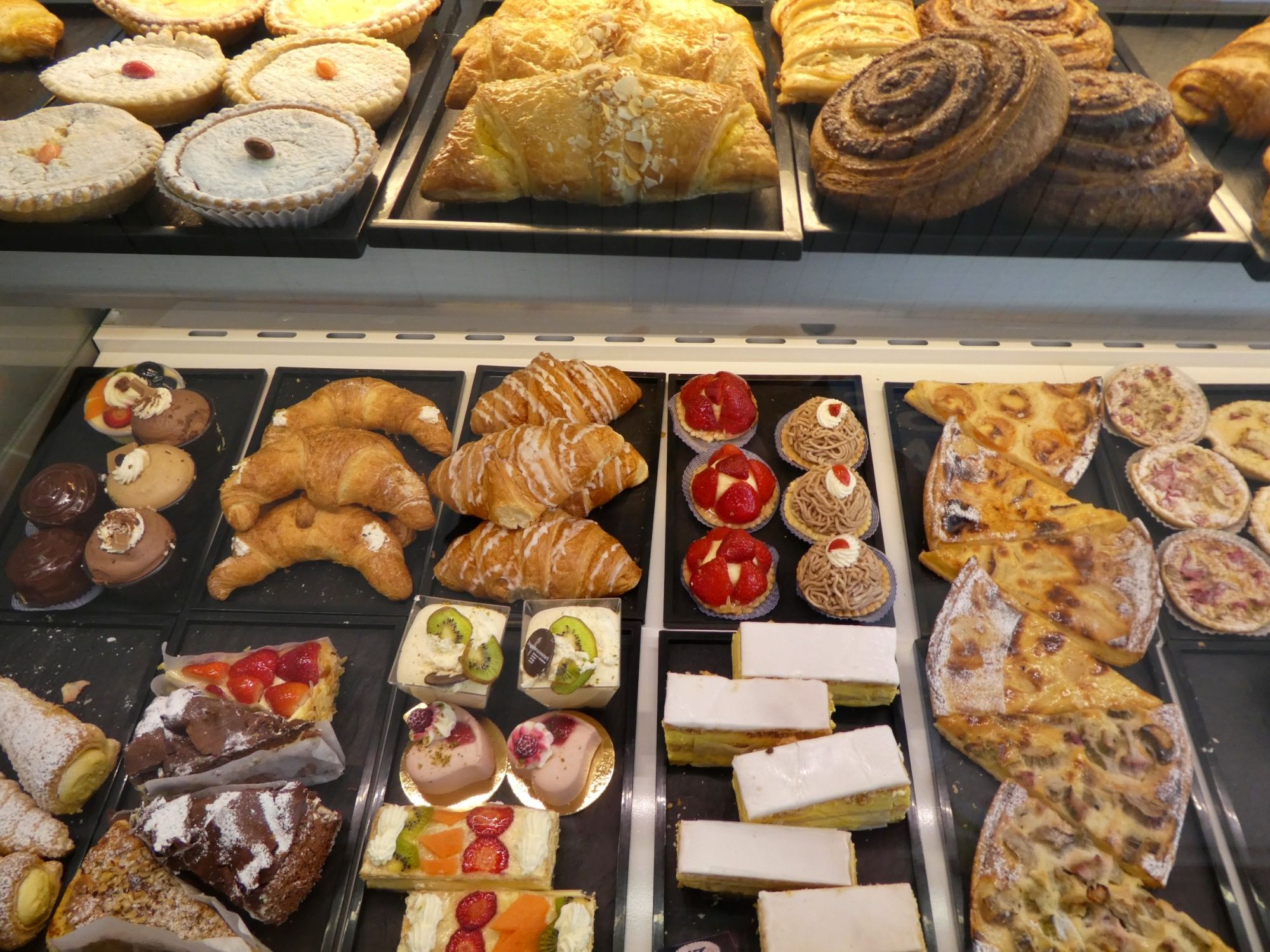 Ζαχαροπλαστείο σε αρτοποιείο με φρέσκα γλυκίσματα όπως κρουασάν, τούρτες και τάρτες.