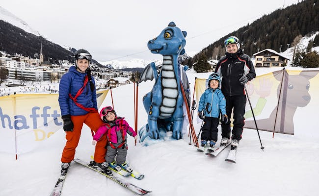 Familien beim Skifahren in Davos mit einem Drachen aus Schnee