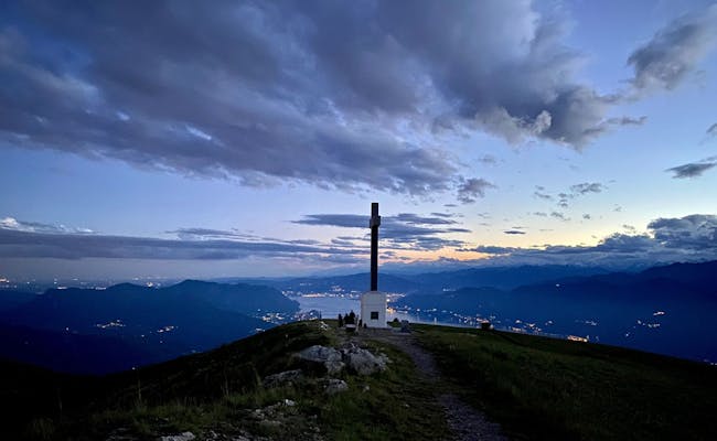 Monte Lema Culmine: vista impressionante su montagne e luci della città al tramonto.