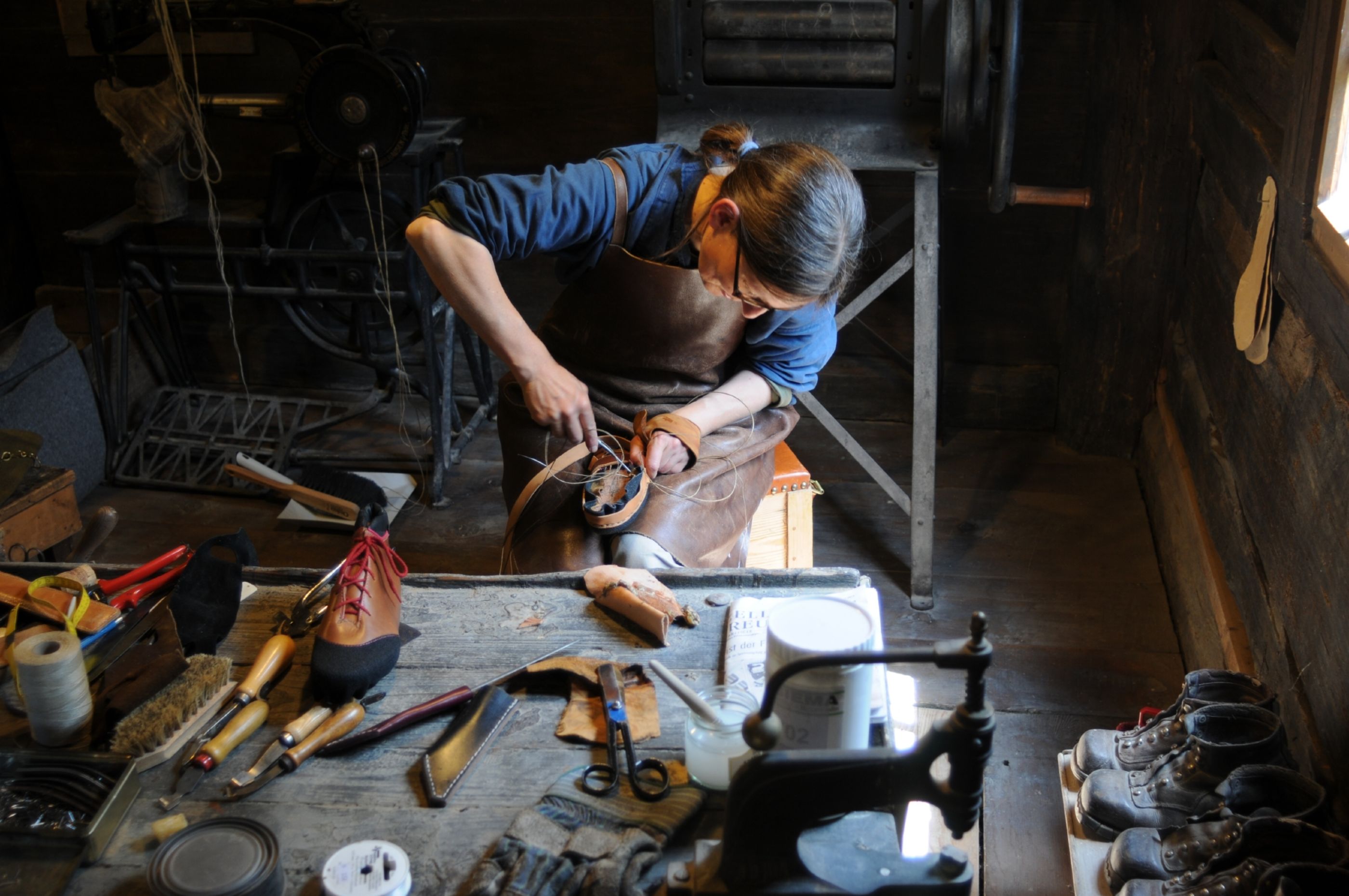 鞋匠在巴伦贝格露天博物馆为鞋子制作皮革