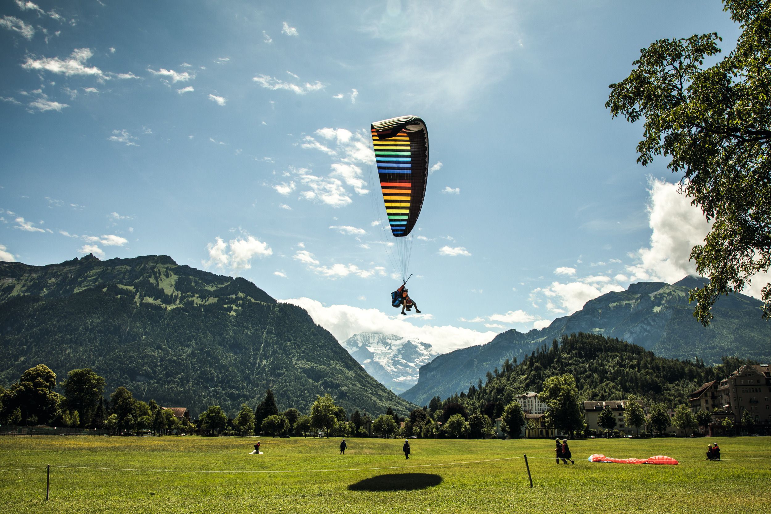 Atterraggio col paracadute a Interlaken, volo estivo sopra montagne e natura, goditi panorami avventurosi.