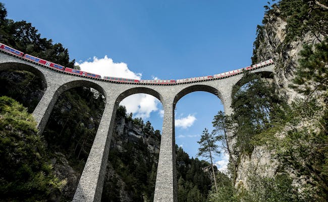 Viaduto Landwasser em Albula Filisur com comboio sob um céu azul
