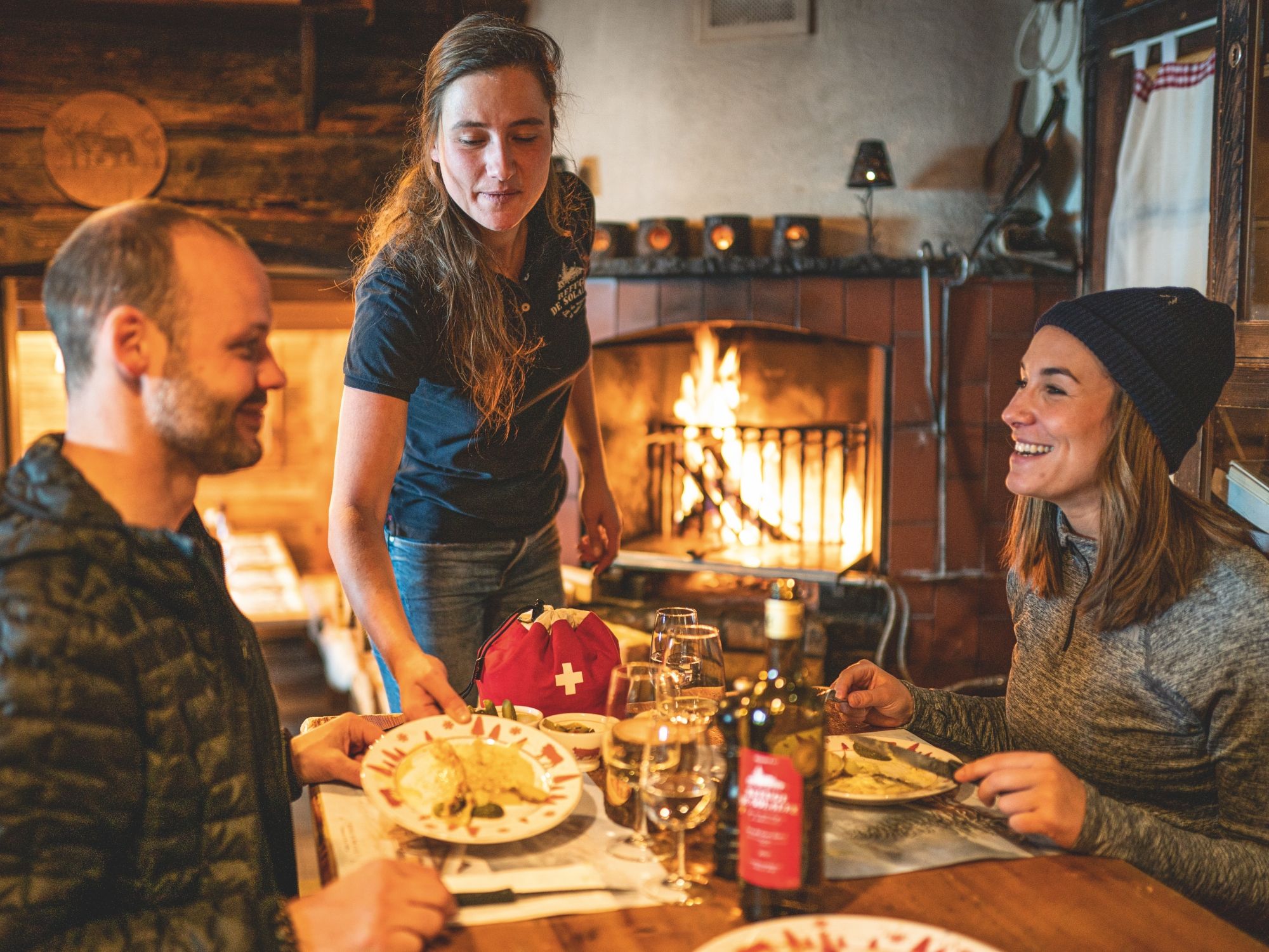 Raclette di Switzerland, orang yang sedang menikmati, hidangan santai di dapur kayu