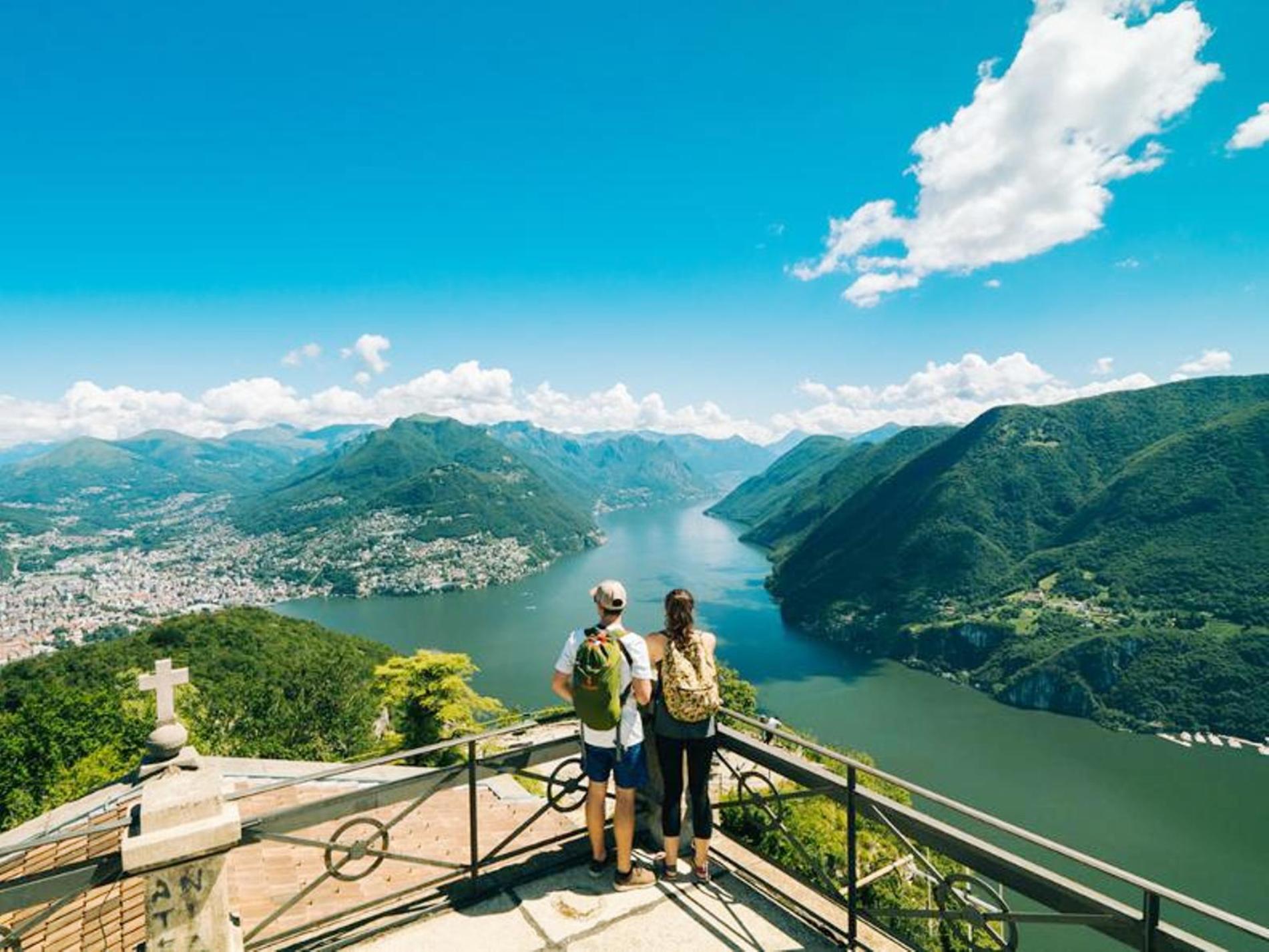 San Salvatore dengan pemandangan Danau Lugano, pasangan menikmati pemandangan di hari yang cerah