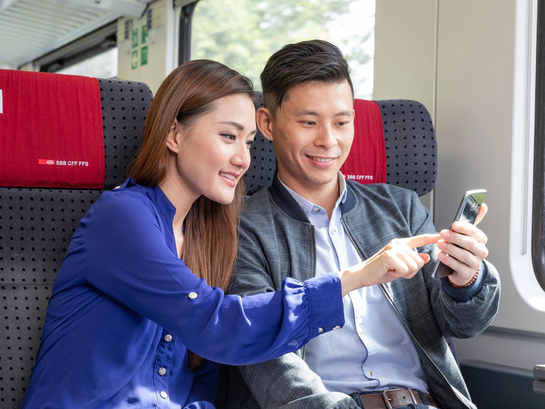 คู่รักใช้ Sparticket ในรถไฟและมองที่สมาร์ทโฟน