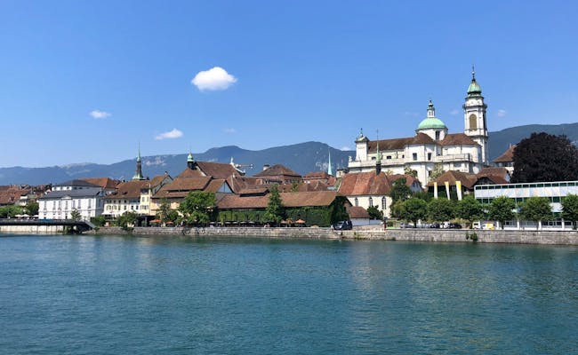 Soloturno: hermosa vista de la ciudad a orillas del Aare con edificios y montañas de fondo
