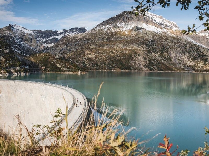Vattenverk på våren framför en lugn sjö och berg.