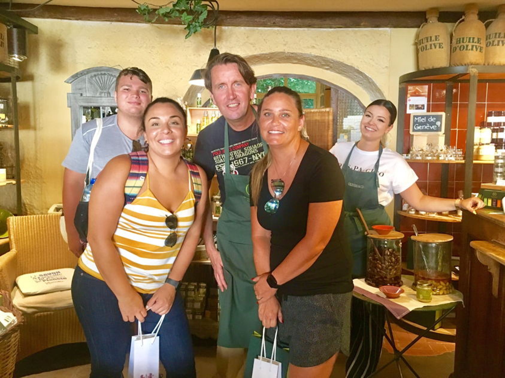 Cucinare durante un corso di vacanza in un ambiente mediterraneo con partecipanti in grembiuli.