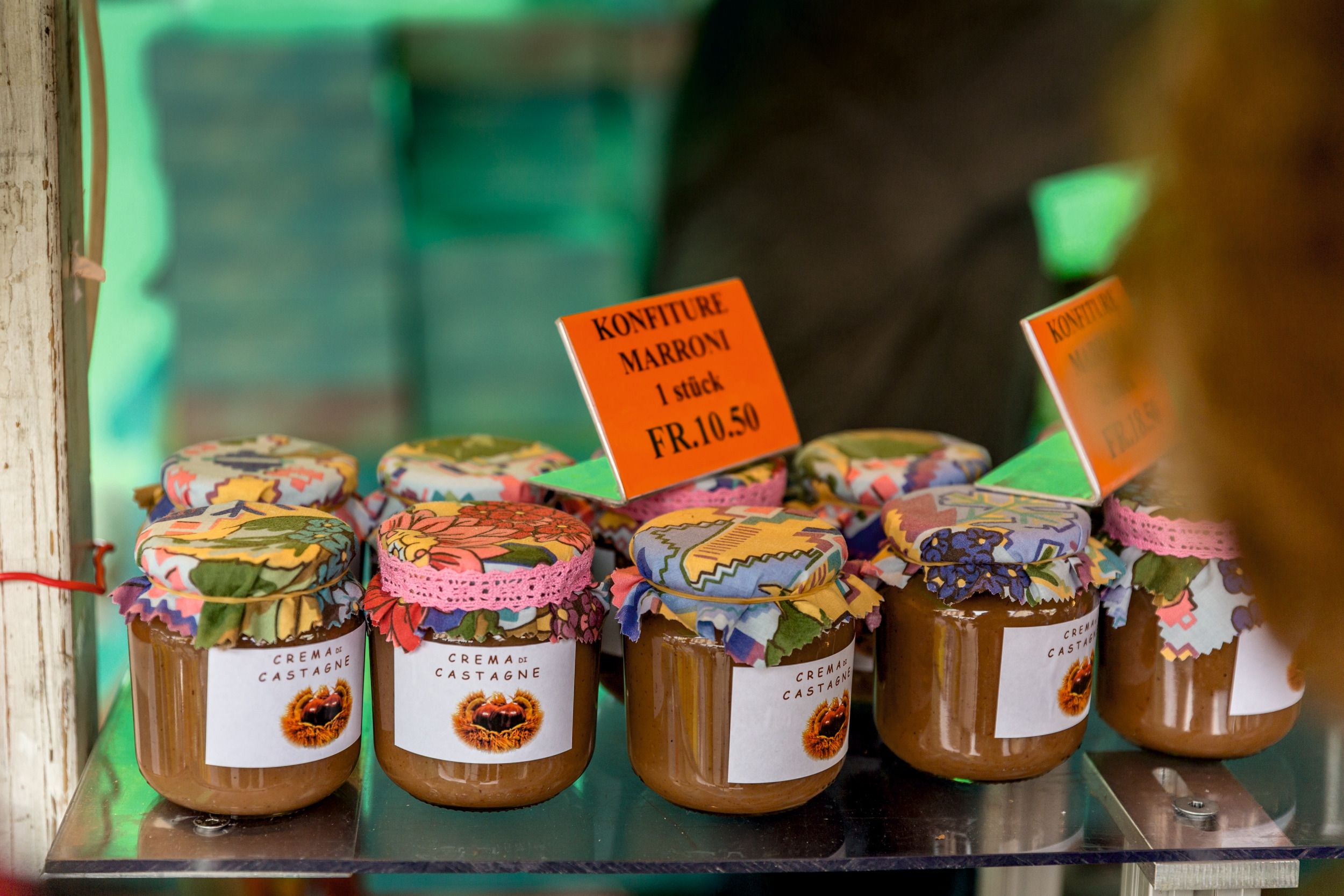 Džemy v barevných sklenicích na festivalu Kaštanů, podzimní atmosféra, Švýcarsko.