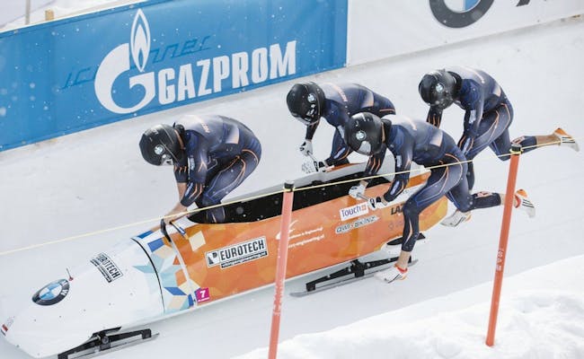 St. Moritz Bobbsläde med fyra idrottare som skjuter en släde.