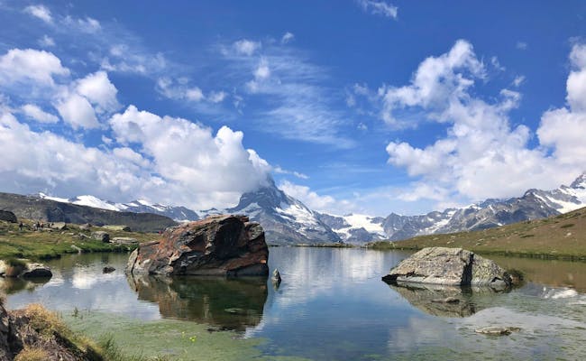 Zermatt: Wandelaar staat bij het heldere meer met de Matterhorn op de achtergrond