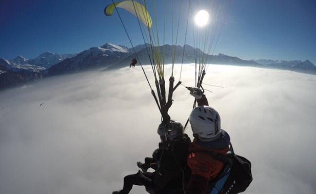 Tandemflug beim Gleitschirmfliegen über den Wolken in Interlaken.