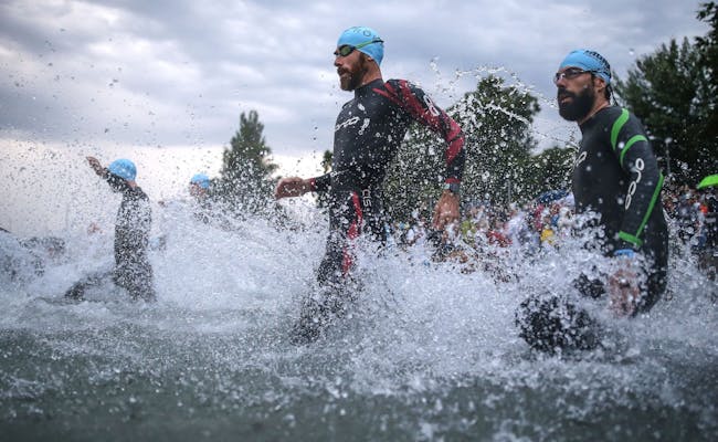 Ironman ธุน เริ่มการแข่งขันว่ายน้ำกับผู้เข้าร่วมในชุดว่ายน้ำ