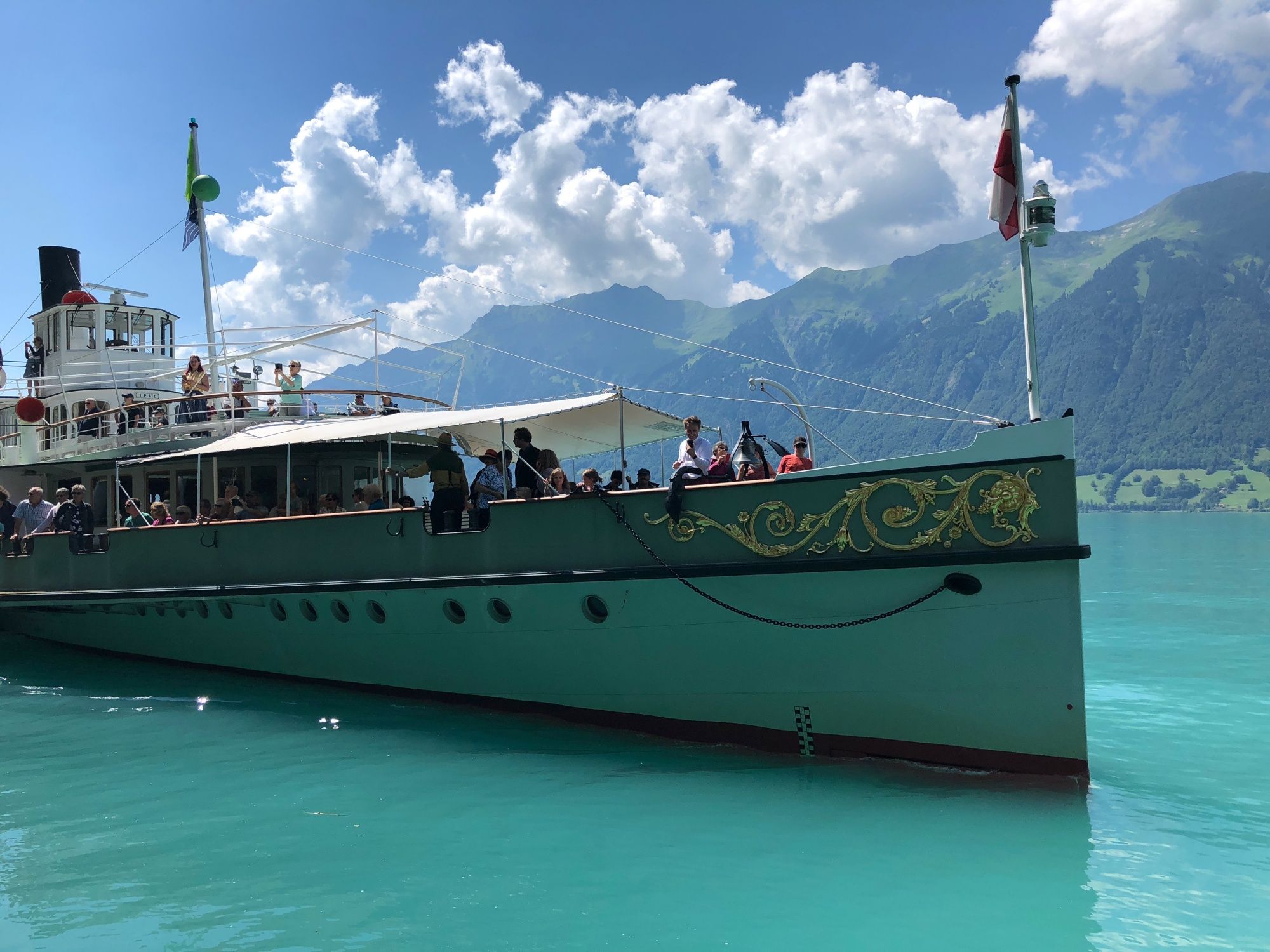 Brienzersee: Bootstour mit Gästen vor Bergen und blauem Wasser in der Sommerlandschaft.