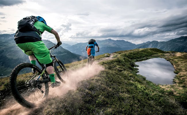 Mountainbike auf Singletrails in Davos mit Blick auf die Berge.