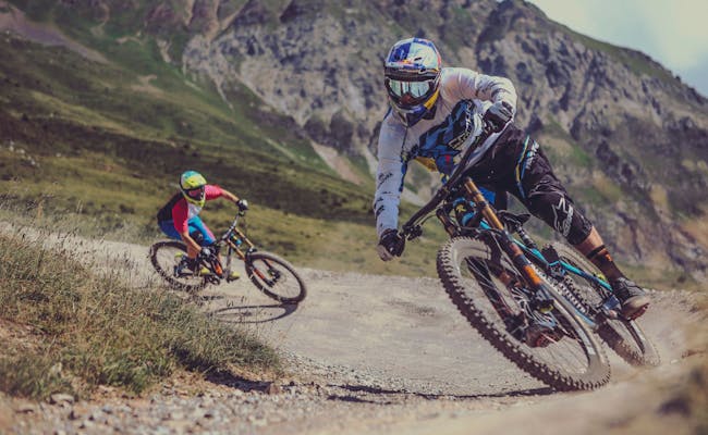Reino do Mountainbike Lenzerheide. Ciclistas na trilha de MTB nos Alpes. Um dia ensolarado.