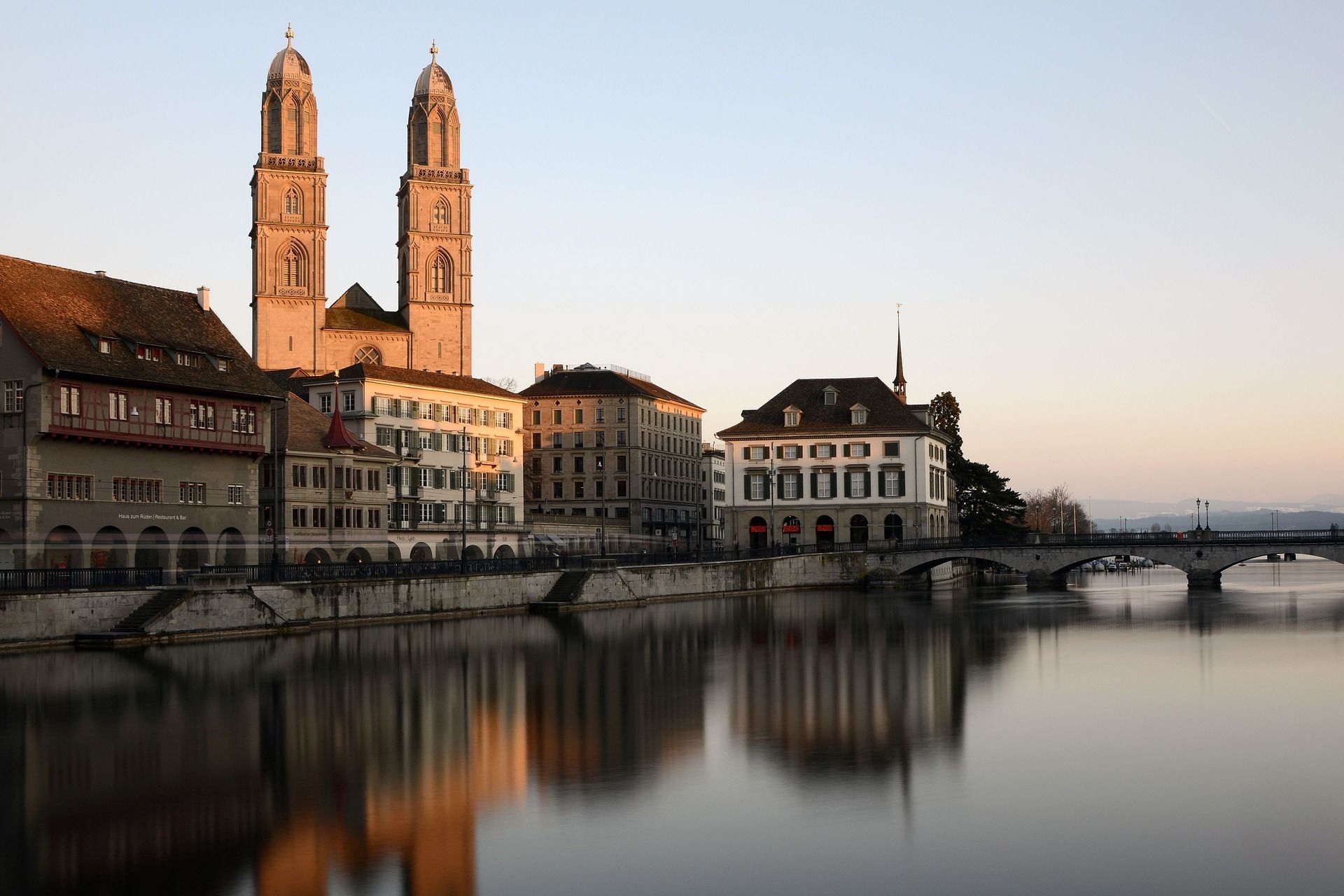 Grossmünster Zurich : bâtiment historique impressionnant au bord de la rivière avec l'architecture urbaine environnante.
