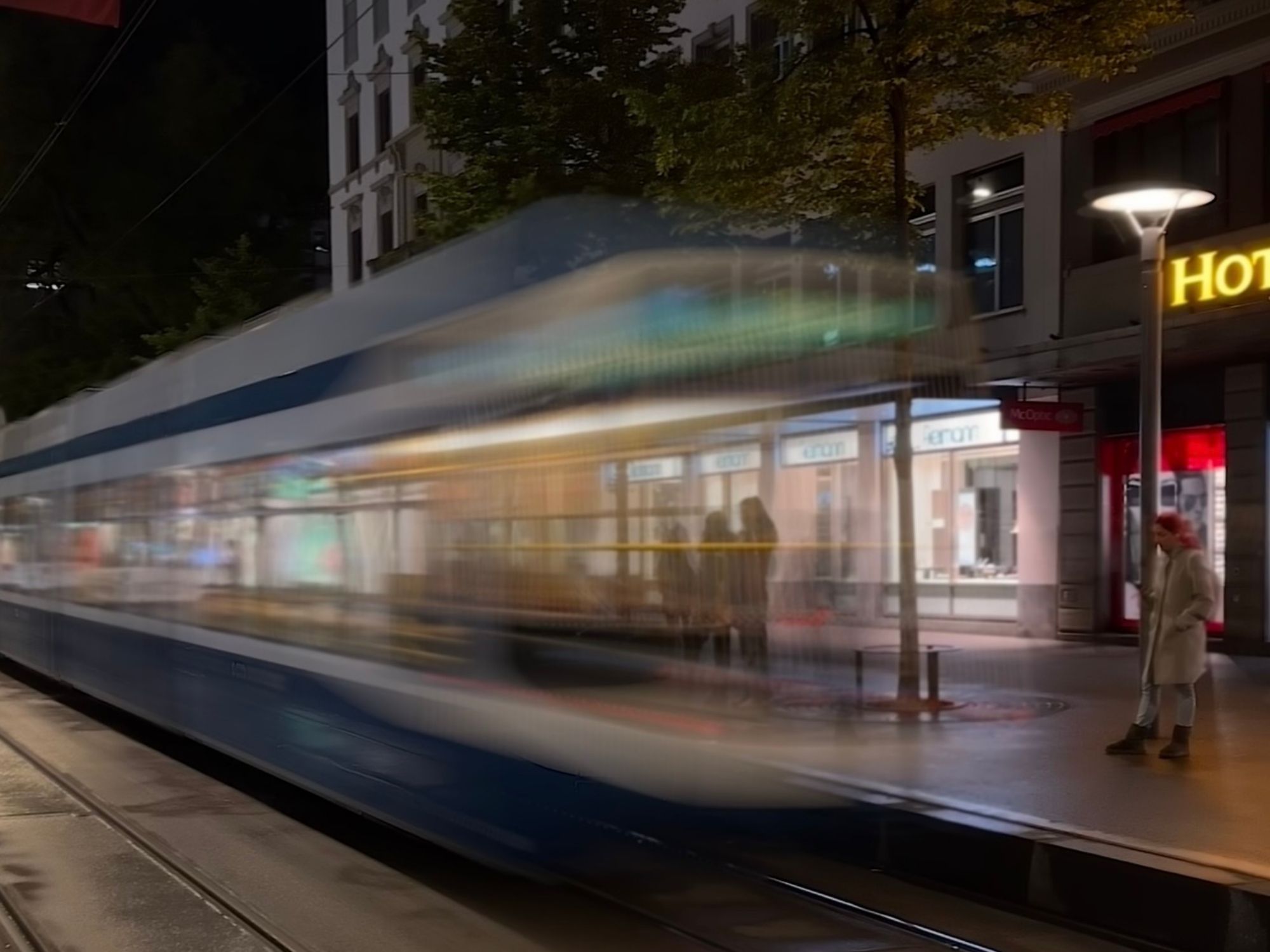도시의 밤에 트램, 도시적인 매력과 빛의 게임이 있는 창의적인 사진.